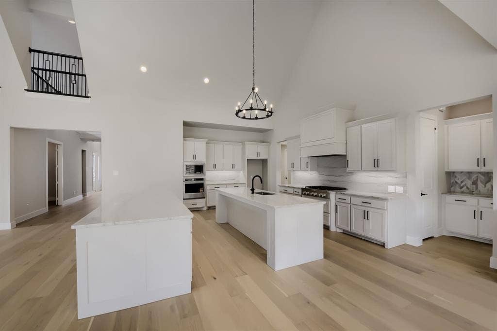 794 White Sage Road, Haslet, TX 76052 Contemporary kitchen featuring two white islands with light countertops, recessed lighting, and wood-finish flooring