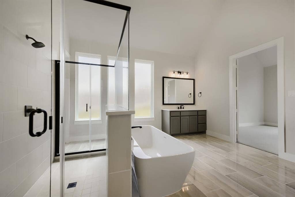 794 White Sage Road, Haslet, TX 76052 Freestanding soaking tub with a floor-mounted faucet, complemented by a glass-enclosed shower with matte black hardware