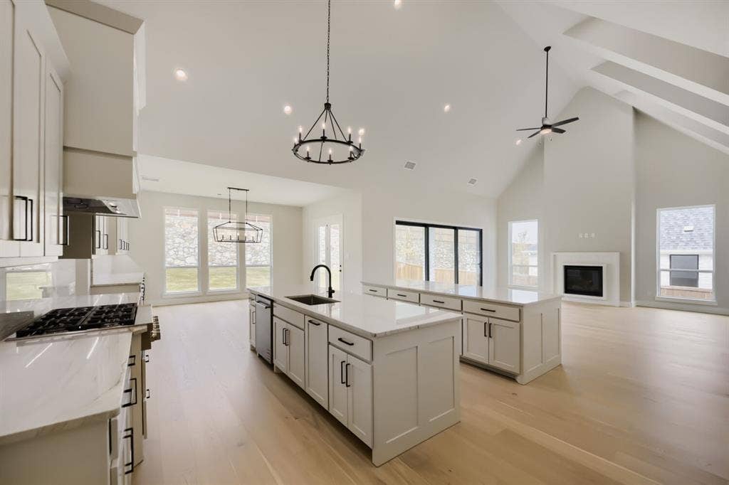 794 White Sage Road, Haslet, TX 76052 Open-concept living space featuring vaulted ceilings, a fireplace, and light wood-finish flooring