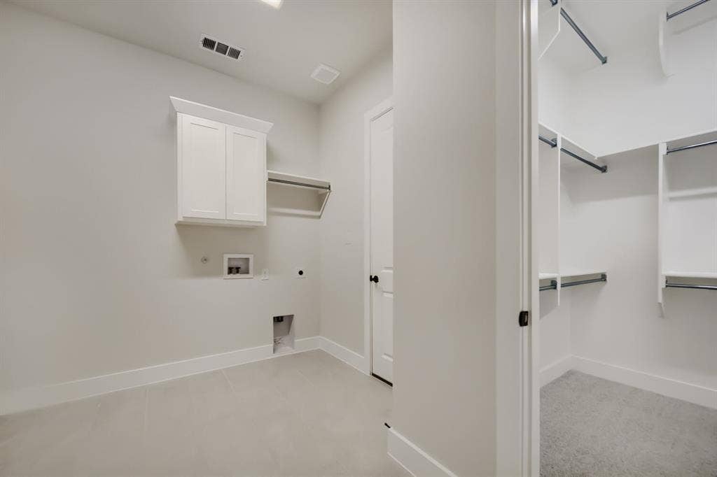 794 White Sage Road, Haslet, TX 76052 Dedicated laundry area featuring a white shaker-style wall cabinet and an integrated hanging rod