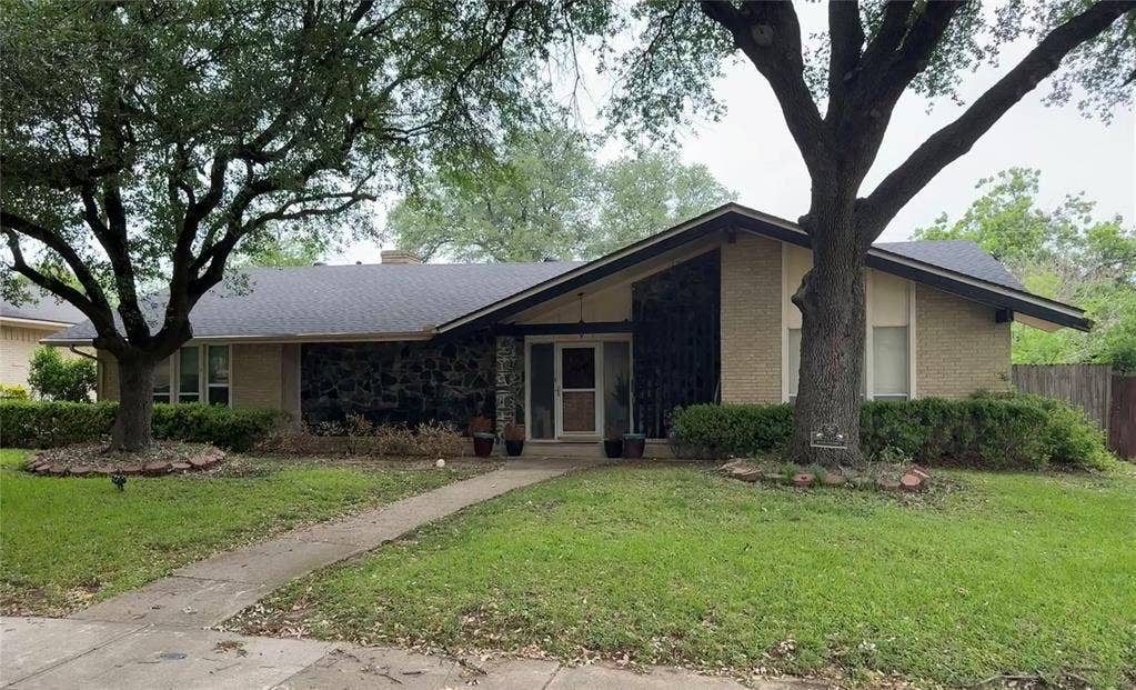 Mid-century modern ranch-style home featuring a brick and stone facade