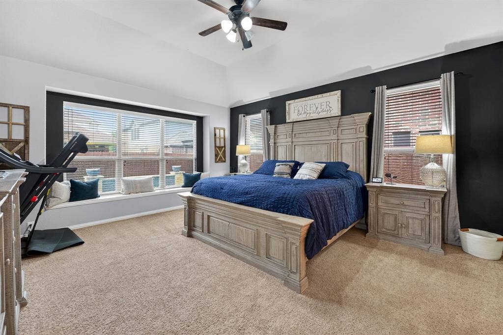 2760 Explorador, Grand Prairie, TX 75054 Carpeted bedroom featuring a vaulted ceiling with a ceiling fan, a window seat with ample natural light, and dark accent walls