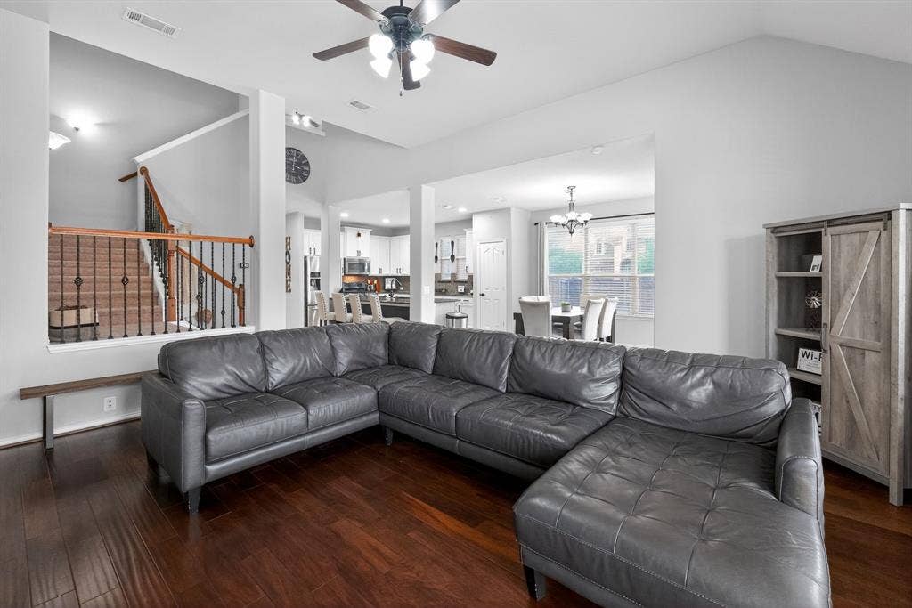 2760 Explorador, Grand Prairie, TX 75054 Open-concept living area featuring laminate flooring, a contemporary ceiling fan, and staircase with dark iron balusters