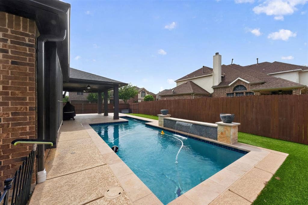 2760 Explorador, Grand Prairie, TX 75054 Backyard featuring a rectangular swimming pool with a water feature, a covered patio, and artificial turf