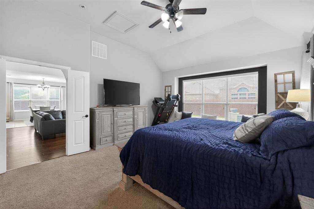 2760 Explorador, Grand Prairie, TX 75054 Carpeted bedroom featuring a vaulted ceiling with a ceiling fan, a spacious window with blinds, and a wide entryway