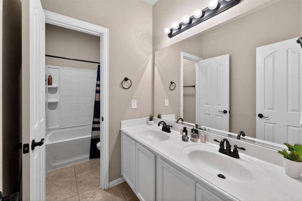 2760 Explorador, Grand Prairie, TX 75054 Upstairs Bathroom - Double vanity with integrated sinks, white cabinetry, matte black fixtures, and a large wall-mounted mirror