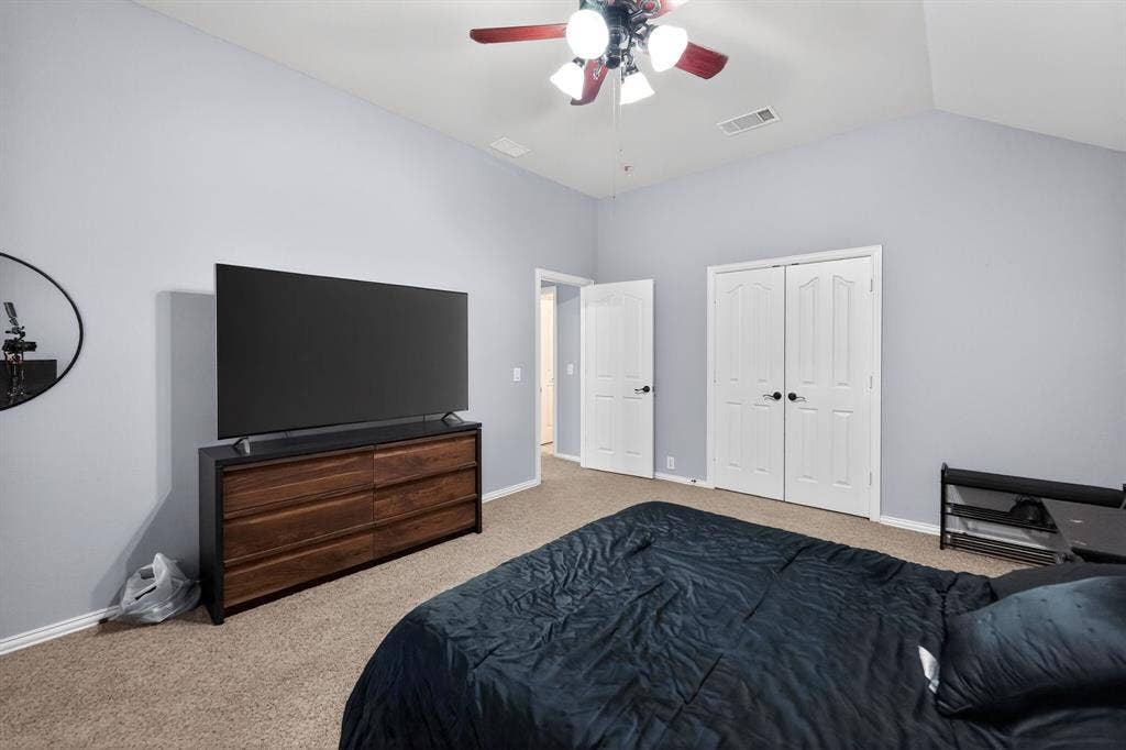 2760 Explorador, Grand Prairie, TX 75054 Upstairs - Bedroom # 4 featuring vaulted ceilings enhance this carpeted room featuring a ceiling fan with light fixture and white double door closet.
