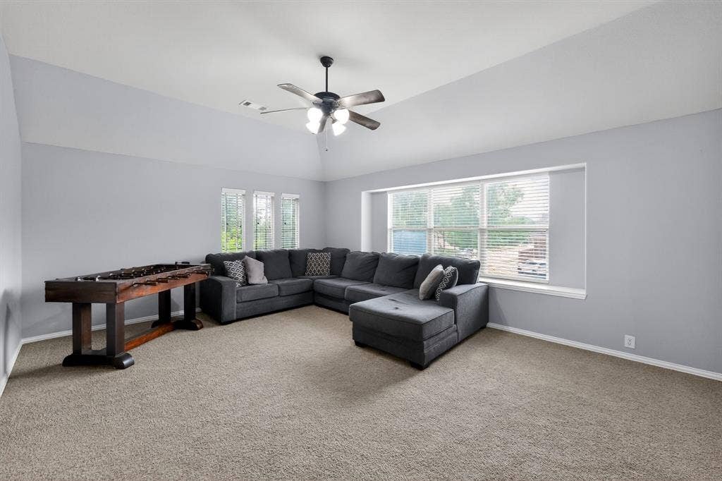 2760 Explorador, Grand Prairie, TX 75054 Upstairs spacious entertainment room featuring vaulted ceilings, neutral carpeting, and a ceiling fan with integrated lighting