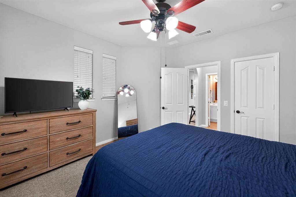 2760 Explorador, Grand Prairie, TX 75054 Downstairs - Bedroom #2 featuring light gray walls, carpet flooring, two windows with blinds, and a ceiling fan with integrated lighting