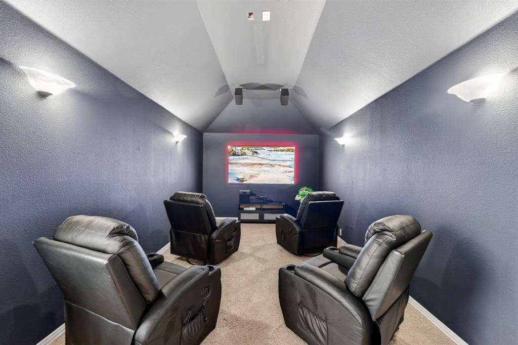 2760 Explorador, Grand Prairie, TX 75054 Upstairs - Dedicated media room featuring a large screen, wall-mounted sconce lighting, speakers, and sloped ceilings
