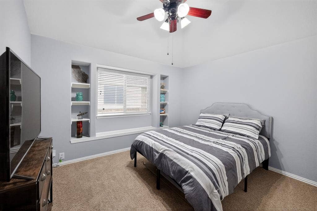 2760 Explorador, Grand Prairie, TX 75054 Upstairs - Bedroom #3 featuring recessed built-in shelving, a large window with blinds, and ceiling fan with integrated lighting