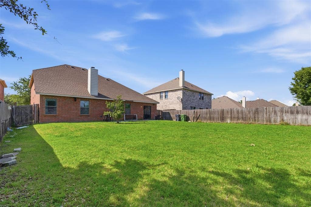 1081 Barrington Drive, Prosper, TX 75078 Expansive backyard with a manicured lawn, full privacy fencing, and mature landscaping