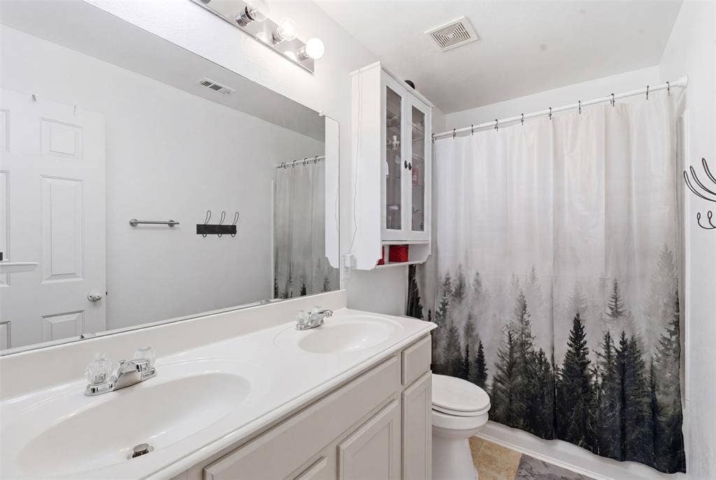 1081 Barrington Drive, Prosper, TX 75078 Bathroom featuring a dual-sink vanity with white countertops, an oversized mirror, tub/shower