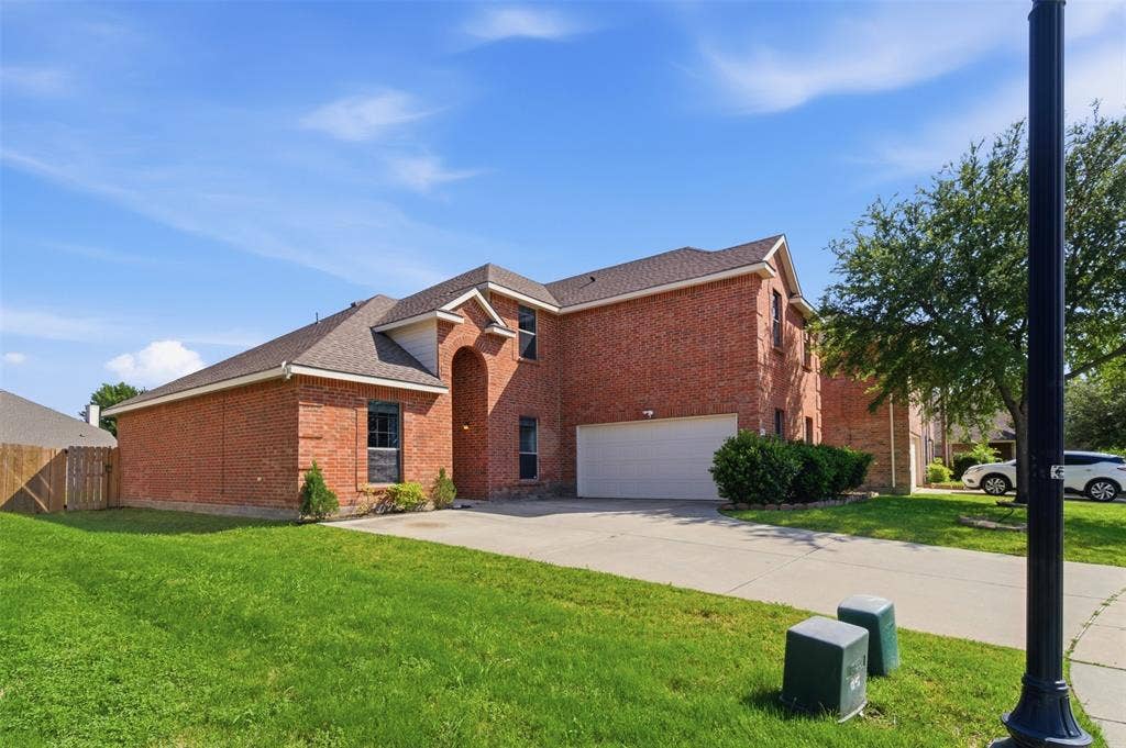 1081 Barrington Drive, Prosper, TX 75078 Two-story brick exterior with an attached garage, gabled roofline, and arched entry