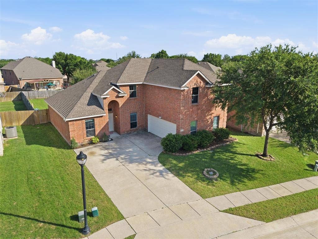 1081 Barrington Drive, Prosper, TX 75078 Brick exterior residence featuring an arched entryway and dark shingle roofing