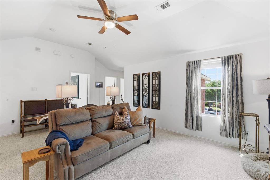 1081 Barrington Drive, Prosper, TX 75078 Spacious living area featuring vaulted ceilings, a ceiling fan with light fixture, a large window, and light-toned carpet flooring