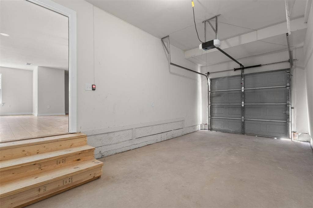 314 NW 15th Street, Grand Prairie, TX 75050 Attached garage with a roll-up door, automatic opener, and concrete flooring