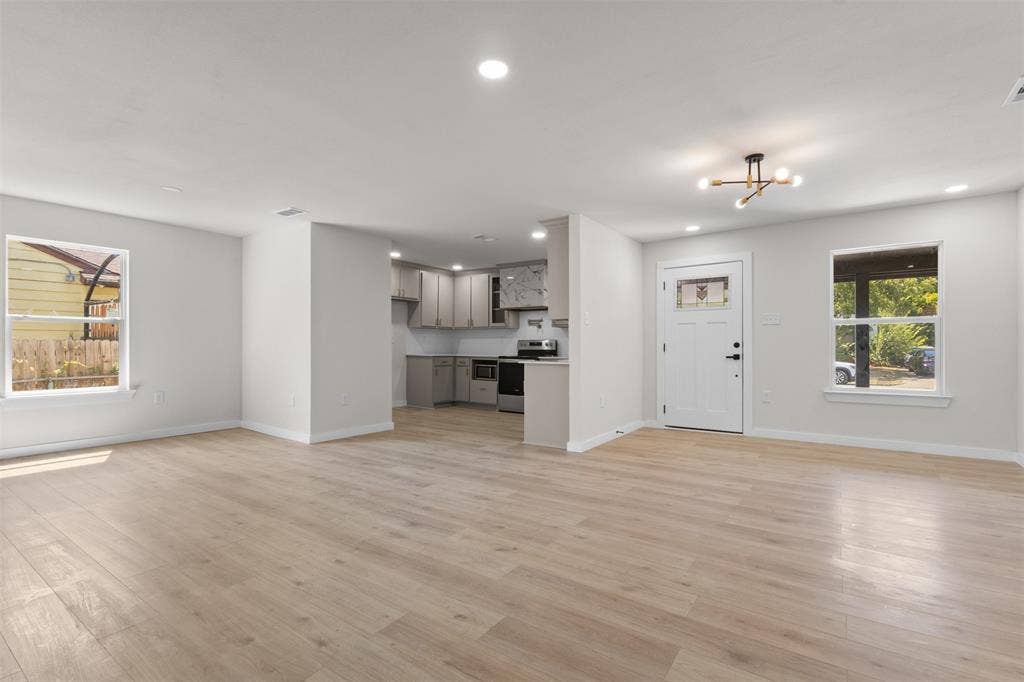 314 NW 15th Street, Grand Prairie, TX 75050 Open-concept living space with light wood-finish flooring, recessed lighting, and a modern ceiling fixture