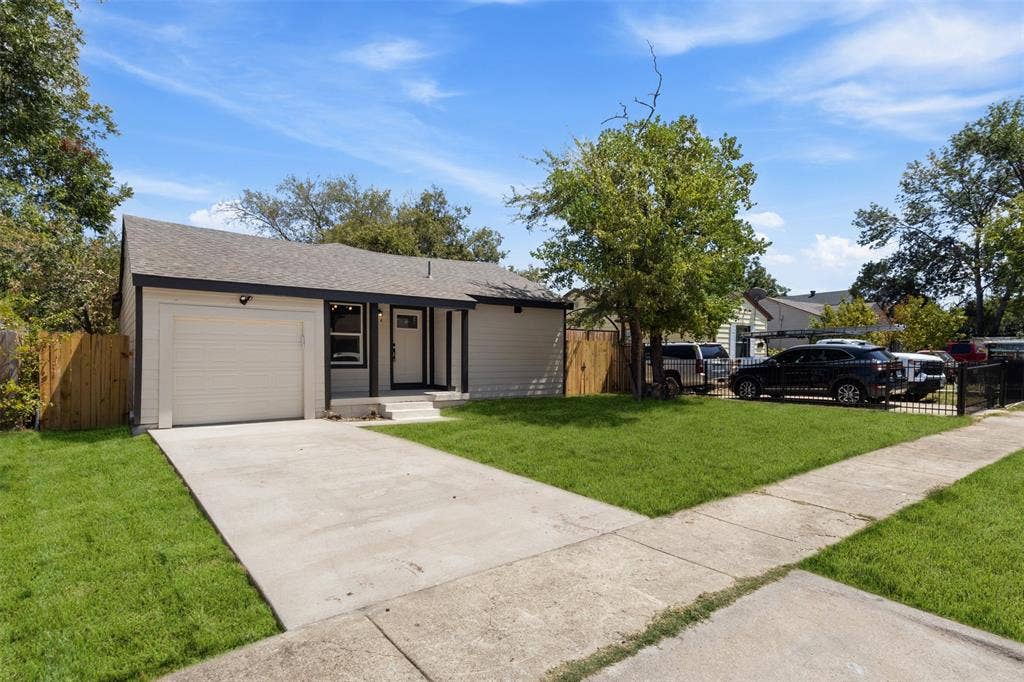 314 NW 15th Street, Grand Prairie, TX 75050 Contemporary exterior with light siding, dark trim, an attached garage, a concrete driveway, and a manicured lawn