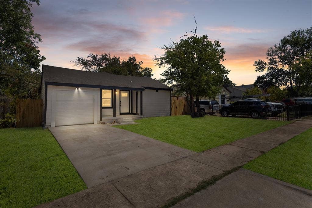 314 NW 15th Street, Grand Prairie, TX 75050 Contemporary exterior with a dark-pitched roof, white garage door, and a concrete driveway
