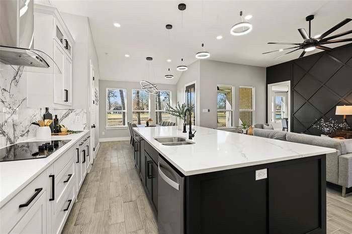 203 Saint Andrews Drive, Mabank, TX 75156 Expansive kitchen island featuring a dual basin sink, white countertops, and integrated dishwasher