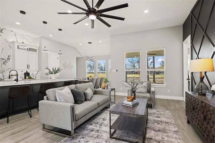 203 Saint Andrews Drive, Mabank, TX 75156 Open-concept living area with wood-finish flooring and a contemporary black ceiling fan