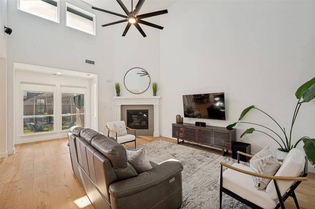 961 Gladewater Drive, Prosper, TX 75078 Natural lighting and a cozy fireplace create a comforting atmosphere in this living space