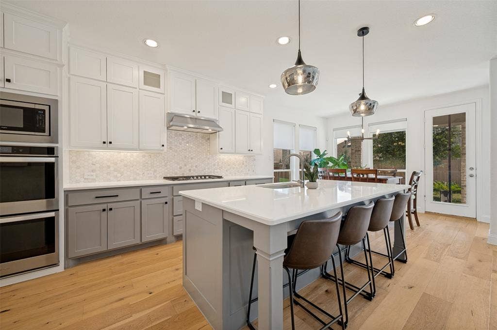 961 Gladewater Drive, Prosper, TX 75078 With trending backsplash, neutral tones, light counter tops and ample storage space, this culinary space is sure to please from everyday routine to entertaining on the weekends!