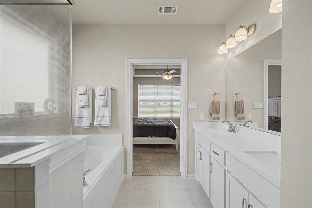 185 Chester Road, Springtown, TX 76082 Bathroom featuring a double vanity with white cabinetry, light countertops, and an integrated rectangular sink