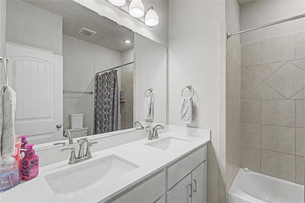 185 Chester Road, Springtown, TX 76082 Bathroom featuring a double vanity with white countertops, undermount sinks, and brushed nickel faucets