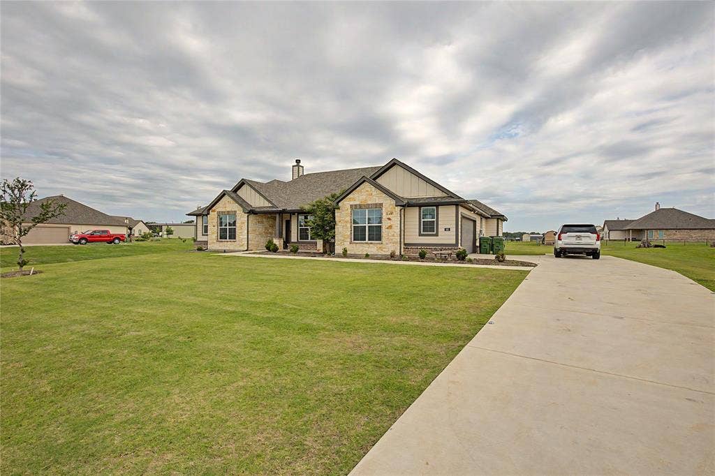 185 Chester Road, Springtown, TX 76082 Stone and siding exterior with a concrete driveway, established lawn, and landscaping