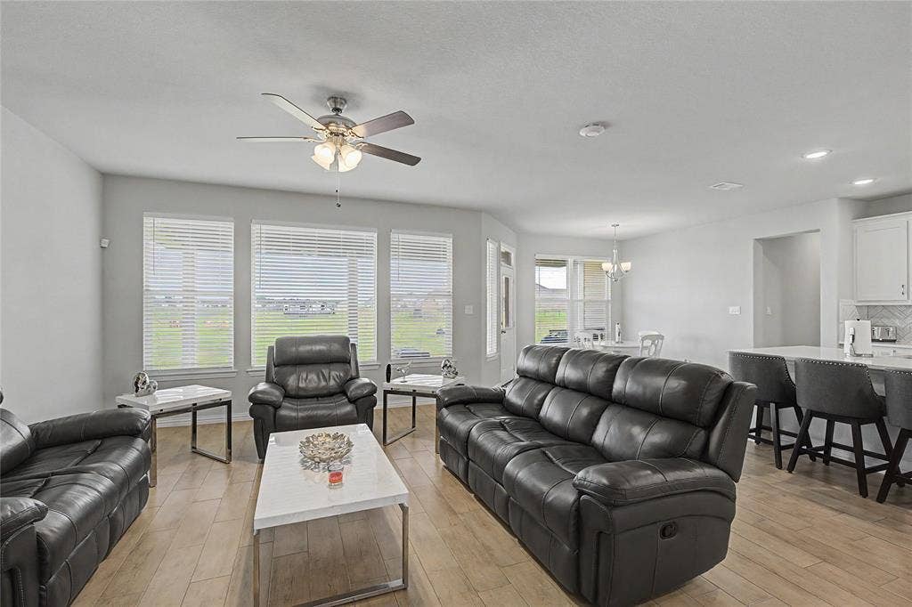 185 Chester Road, Springtown, TX 76082 Open-concept living area featuring a ceiling fan with integrated lighting, wood-finish flooring, and white window blinds