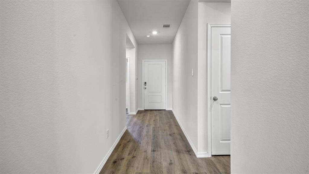 200 Bandit Trail, Terrell, TX 75160 Hallway featuring wood-finish flooring, white baseboards, recessed lighting, and a white paneled door