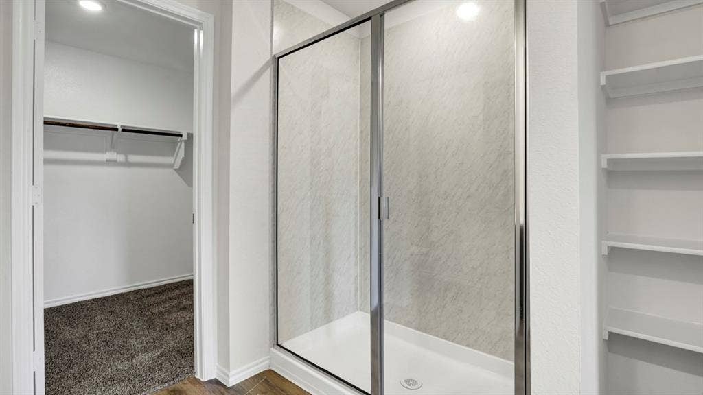 200 Bandit Trail, Terrell, TX 75160 Walk-in shower with sliding glass doors, white shower pan, and grey-patterned tile surround