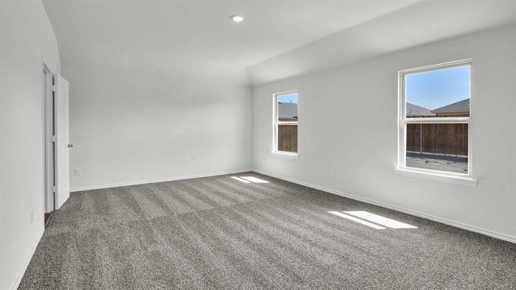 200 Bandit Trail, Terrell, TX 75160 Spacious room featuring neutral carpeting, white walls, two windows, recessed lighting, and a paneled door