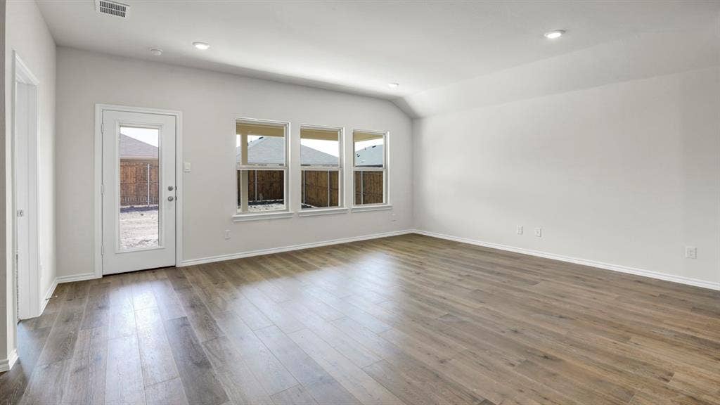 200 Bandit Trail, Terrell, TX 75160 Spacious room featuring wood-finish flooring, vaulted ceilings, recessed lighting, and multiple windows