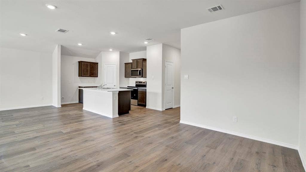 200 Bandit Trail, Terrell, TX 75160 Open-concept living area featuring wood-finish flooring, recessed lighting, and a kitchen with dark wood cabinetry