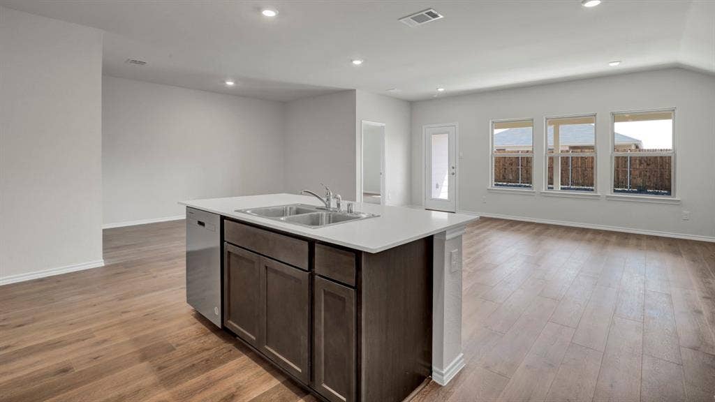 200 Bandit Trail, Terrell, TX 75160 Kitchen island with dark wood cabinetry, a double basin sink, and a light-toned countertop