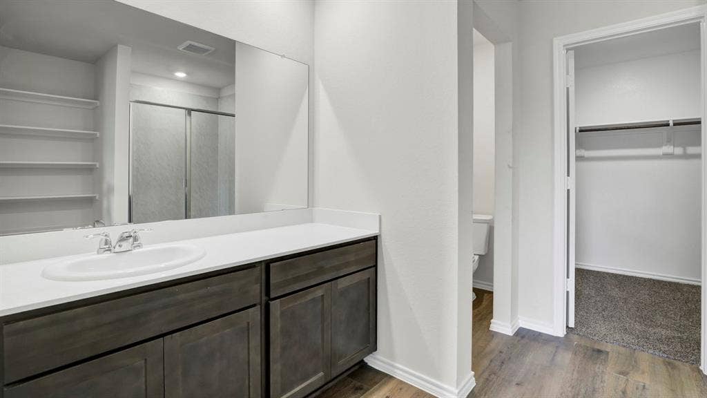 200 Bandit Trail, Terrell, TX 75160 Bathroom featuring a double vanity with an integrated sink, dark wood-finish cabinetry, and a large wall-mounted mirror