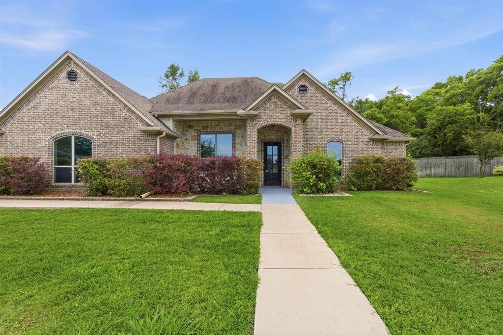 7765 Hickory Spring Lane, Tyler, TX 75703 Brick exterior with architectural gables, arched entry, and a contrasting dark front door