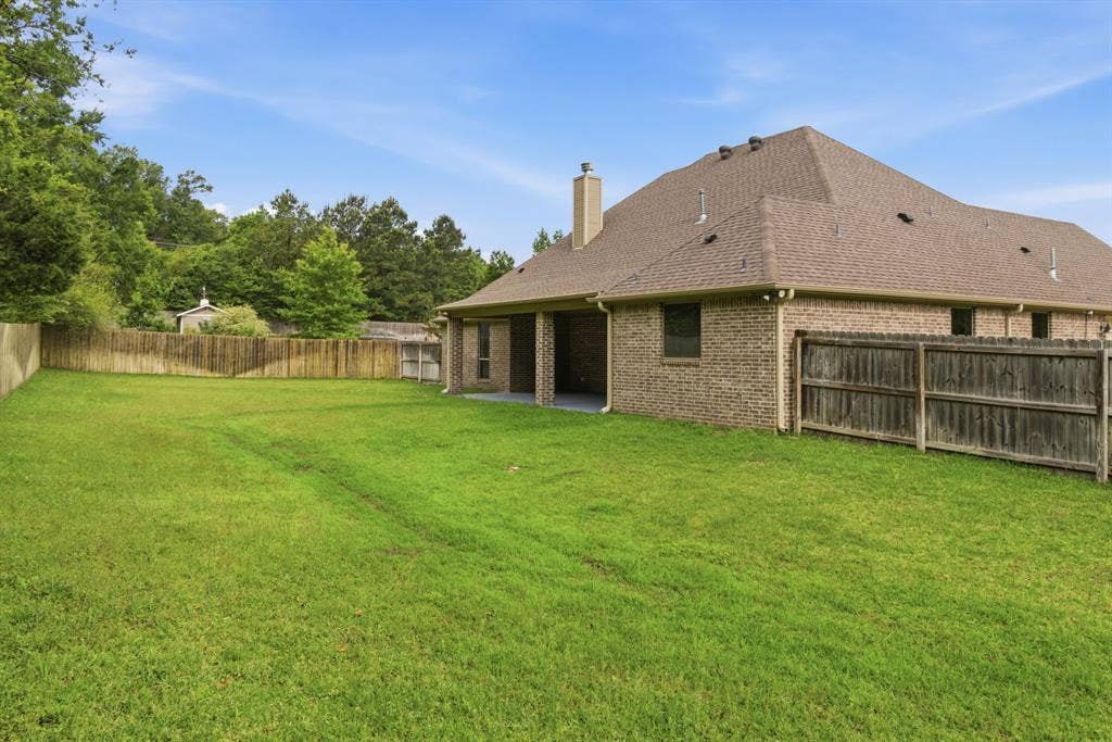 7765 Hickory Spring Lane, Tyler, TX 75703 Expansive grassy yard enclosed by a wood privacy fence