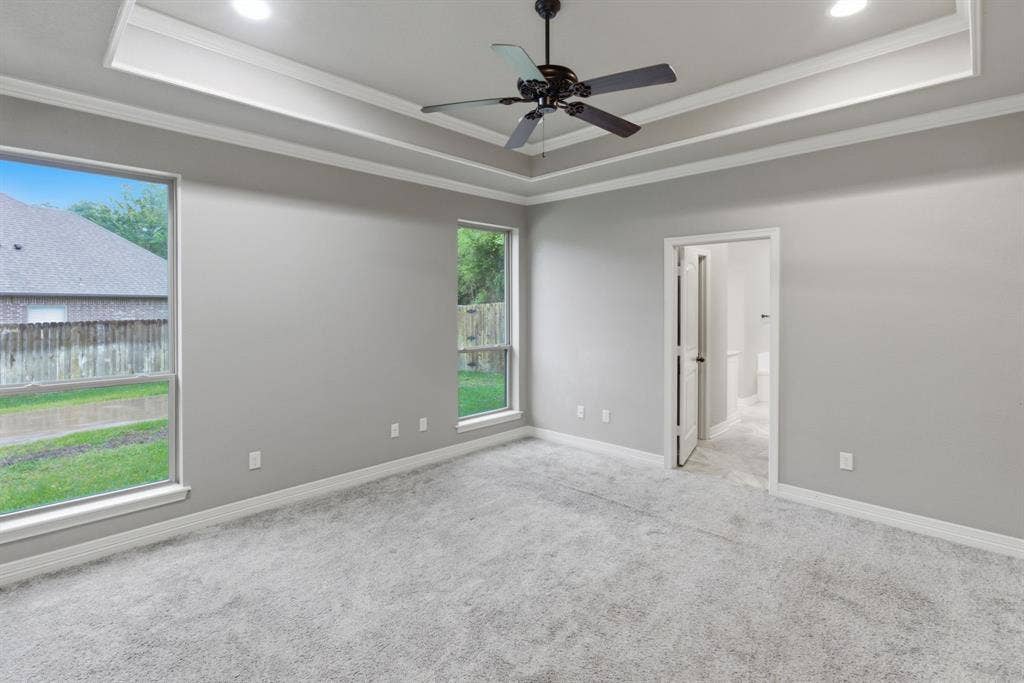 7765 Hickory Spring Lane, Tyler, TX 75703 Spacious room featuring tray ceilings with recessed lighting, a ceiling fan, and plush carpeting