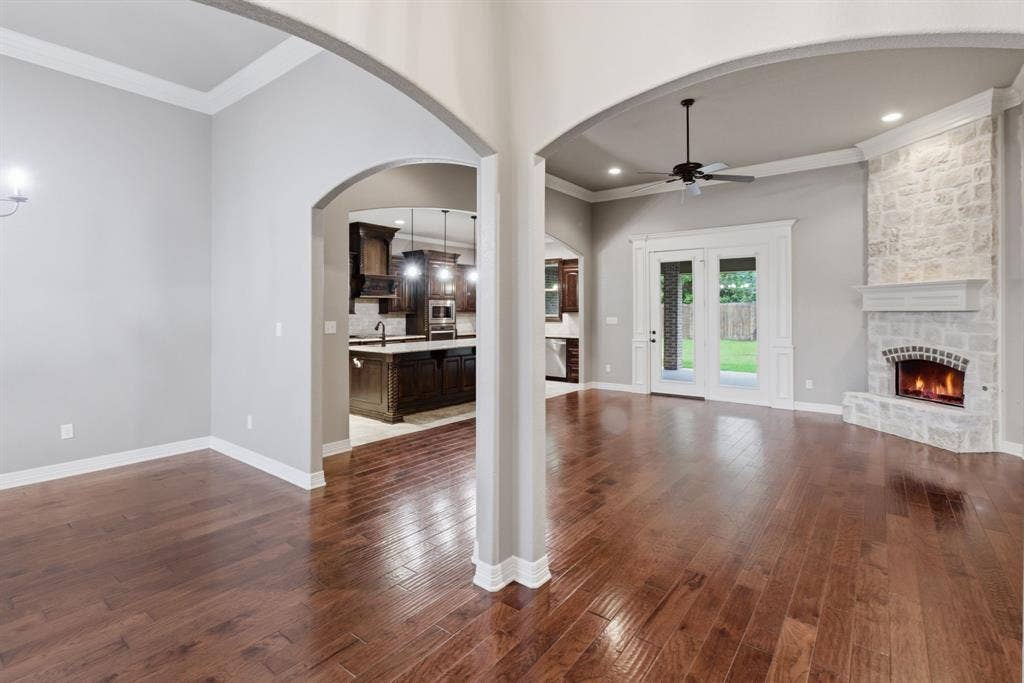 7765 Hickory Spring Lane, Tyler, TX 75703 Spacious living area featuring wood-finish flooring, a stone fireplace with a substantial mantel, and white trim