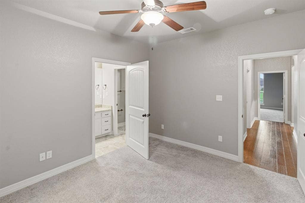 7765 Hickory Spring Lane, Tyler, TX 75703 Carpeted room with a ceiling fan featuring wood-finish blades, light gray walls, and white trim