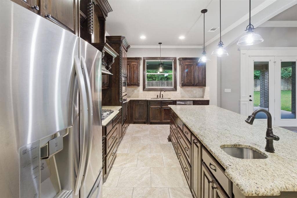 7765 Hickory Spring Lane, Tyler, TX 75703 Kitchen featuring a large central island with a built-in sink and pendant lighting