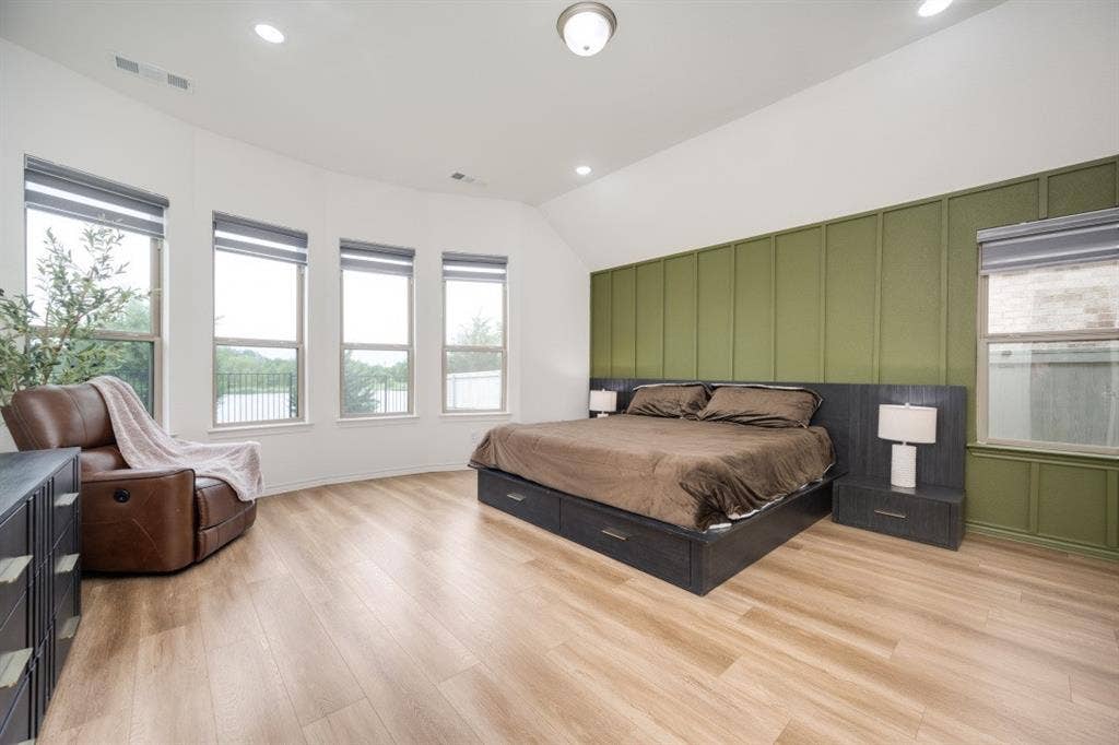 2813 Walker Way, Northlake, TX 76247 Spacious room featuring wood-finish flooring, a vaulted ceiling with recessed lighting, and a prominent accent wall with vertical paneling