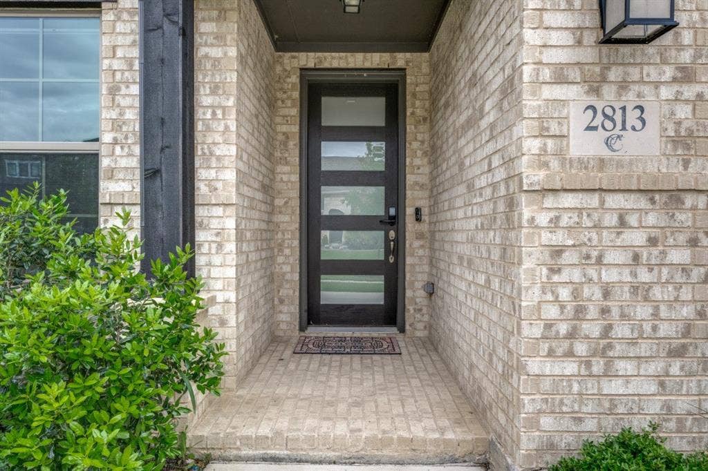 2813 Walker Way, Northlake, TX 76247 Residential property featuring a dark shingle roof, light-colored brick exterior, and an attached two-car garage