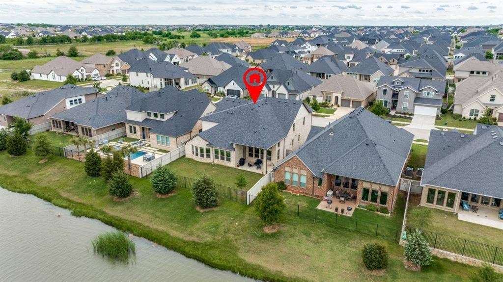 2813 Walker Way, Northlake, TX 76247 Aerial perspective of a residential community featuring a prominent lakefront property with a dark shingle roof