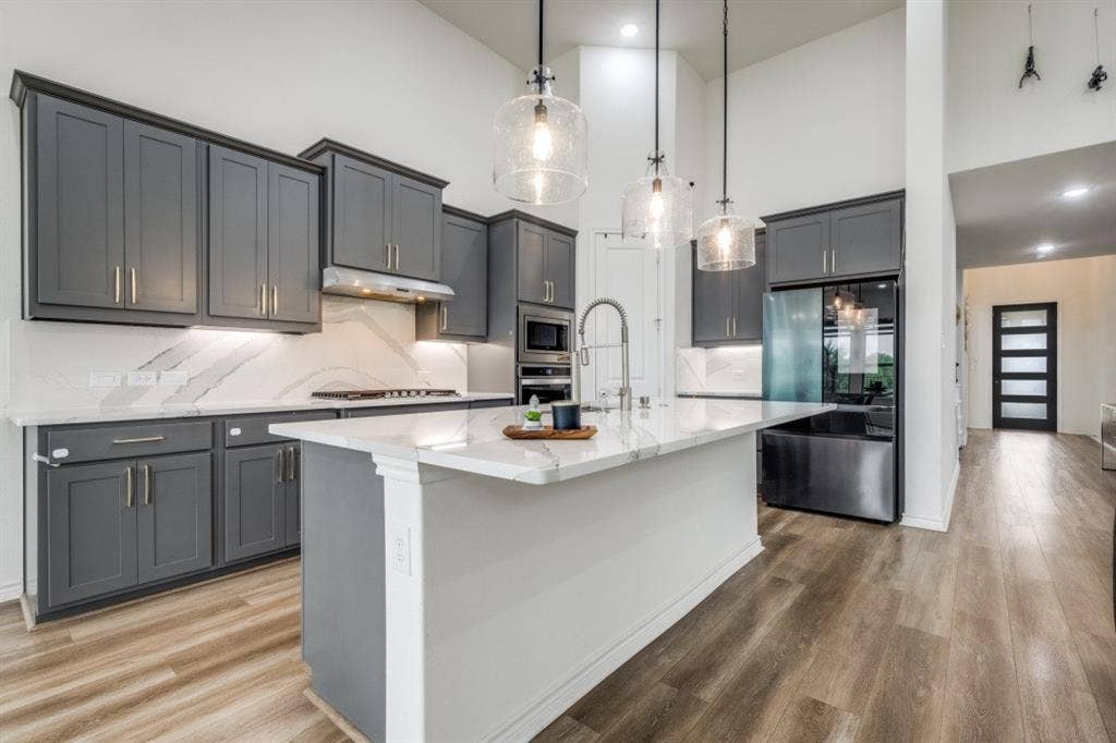 2813 Walker Way, Northlake, TX 76247 Modern kitchen featuring a large central island, gray cabinetry, integrated stainless steel appliances, and wood-finish flooring