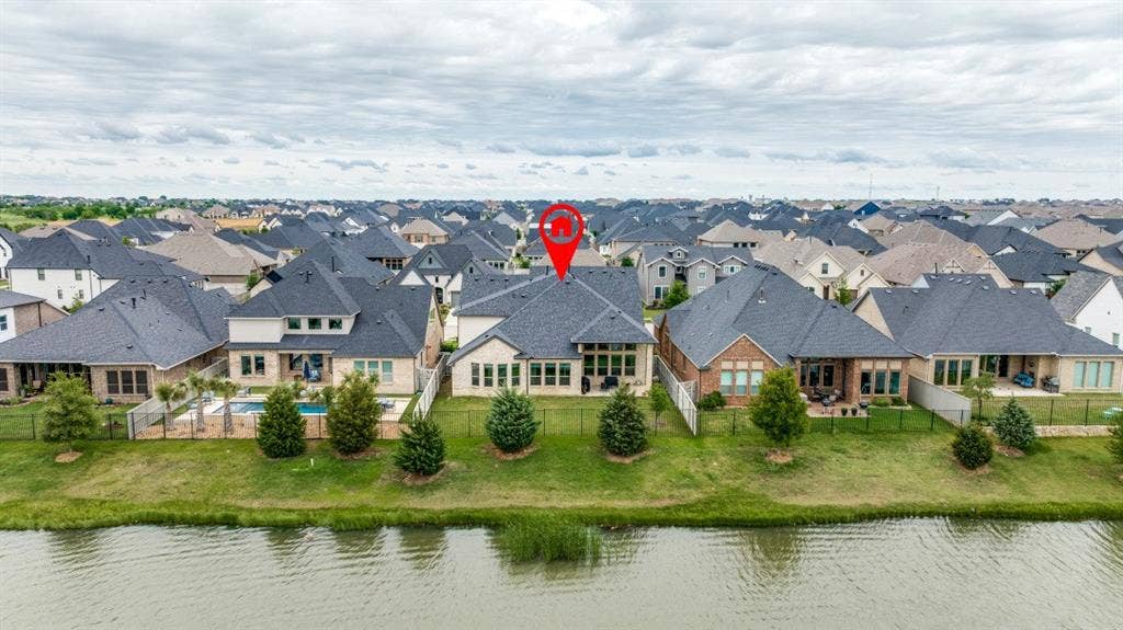 2813 Walker Way, Northlake, TX 76247 Rear elevation featuring a private swimming pool, fenced backyard, covered patio, and manicured lawn, situated along a body of water